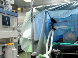 Anesthesiologist Behind Drape Plays Peakaboo with Surgeon Peakaboo