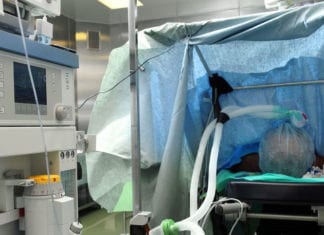 Anesthesiologist Behind Drape Plays Peakaboo with Surgeon Peakaboo