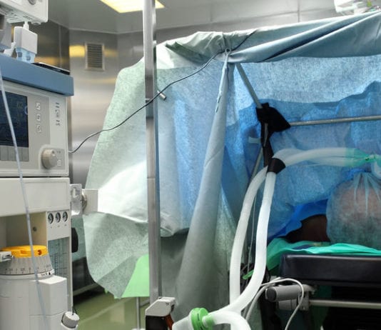 Anesthesiologist Behind Drape Plays Peakaboo with Surgeon Peakaboo