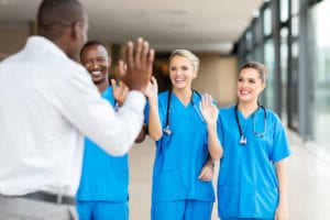 54874903 - rear view of patient waving goodbye to friendly medical team